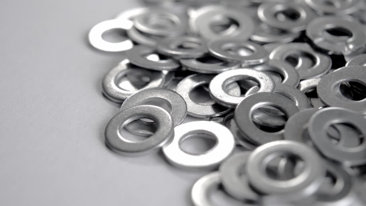 색 배경에 반이는 둥근 금속 고정 화셔의 어리. 금속 강철 크롬 스페이서.