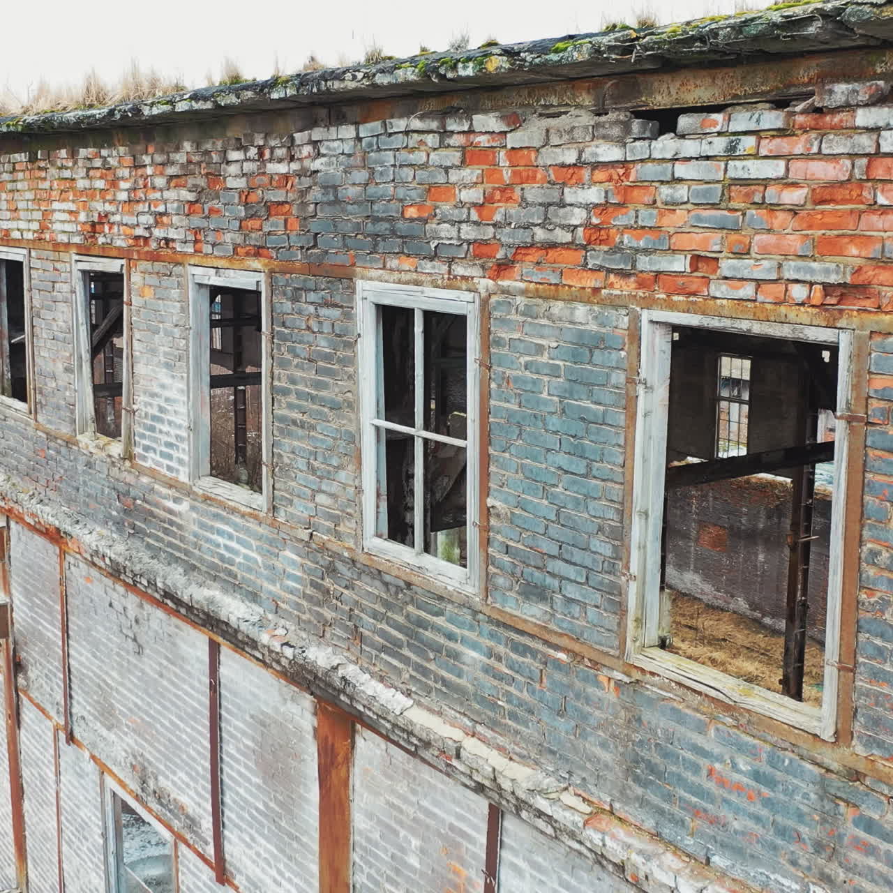 Aerial view of an old factory ruin and broken windows. Old industrial building for demolition.
