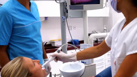 dentist examining male patient with tools