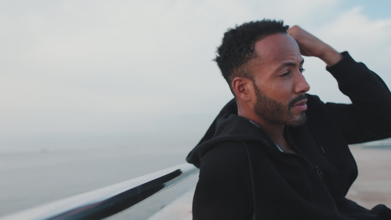 Man in a hoodie by the ocean