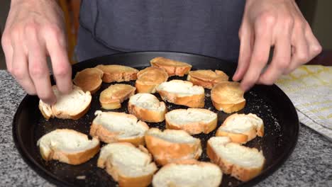 hombre girando el pan aromatizado en la bandeja para tostar en el horno