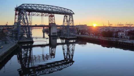 puente transbordador and river as sun rises by horizon, static aerial