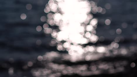 naturaleza abstracta verano océano puesta de sol fondo marino. pequeñas olas en la superficie del agua en movimiento borrosas con luces bokeh del amanecer. vacaciones, vacaciones y concepto de fondo recreativo. cámara lenta