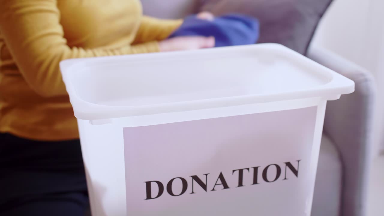 mujer seleccionando ropa para donación. concepto de donaciones de ropa
