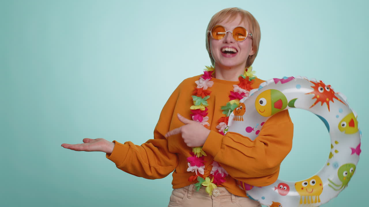 Traveler tourist woman girl hold swimming ring celebrating pointing empty advertising area place