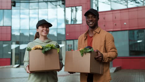 Couriers-holding-boxes-outdoors