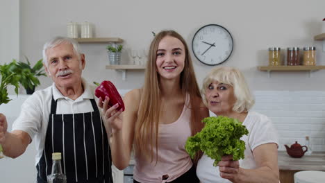 chica con un hombre y una mujer maduros que recomiendan comer alimentos vegetales crudos. dieta de nutrición saludable