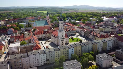 Luftaufnahmen-Von-Prudnik,-Die-Das-Historische-Stadtzentrum-Mit-Seiner-Markanten-Kirche,-Dem-Rathaus-Und-Den-Bezaubernden-Roten-Ziegeldächern-Zeigen