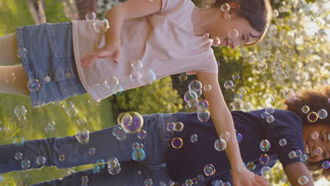 vertical video of smiling boy and girl outdoors having fun playing with bubbles in garden