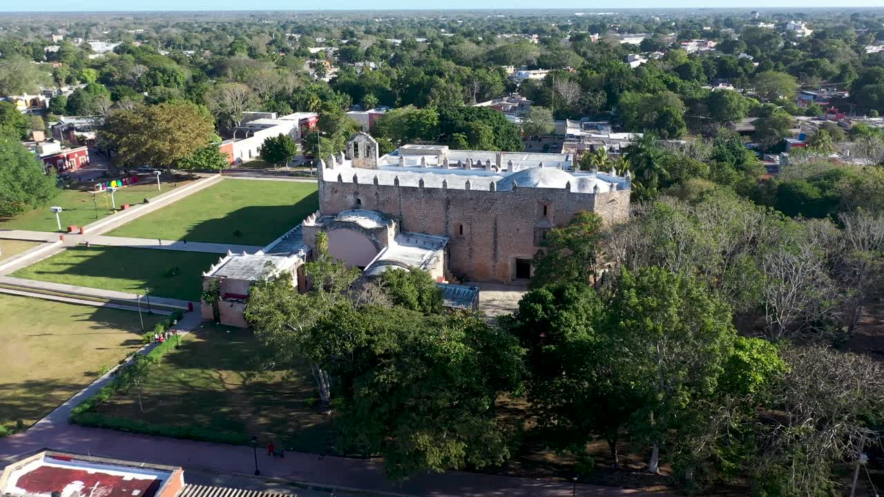Aerial pull back and ascent showing the Convent de San Bernardino in Valladolid, Yucatan, Mexico in early morning