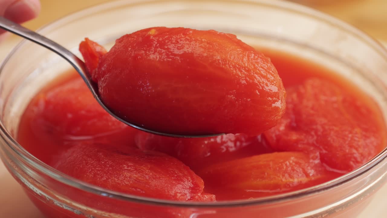 Peeled tomatoes texture, fresh canned tomato Juice sauce, bowl with peeled tomatoes in their own juice, Top view close up, Italian traditional cuisine food.