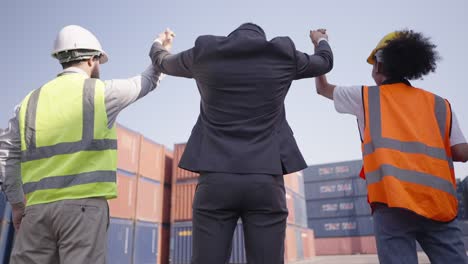 back view. multiracial partners and various professions, working together in logistics business, hold hands and raise hand up to celebrate successful in corporate partnership deal or have investment and employment.