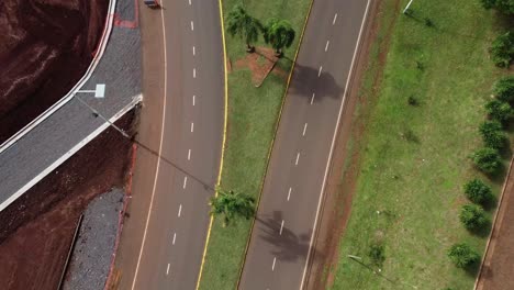 Concurrida-Autopista-De-Varios-Carriles-Rodeada-De-Vegetación-Verde-Al-Borde-De-La-Carretera---Hermoso-Clima-Con-Luz-Solar---Vista-De-Arriba-Hacia-Abajo