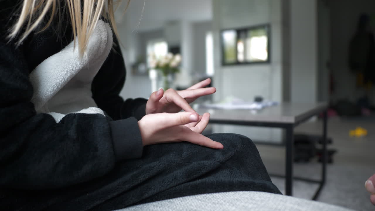 옷을 입은 젊은 금발 소녀가 손가락으로 숫자를 세고, 느린 동작