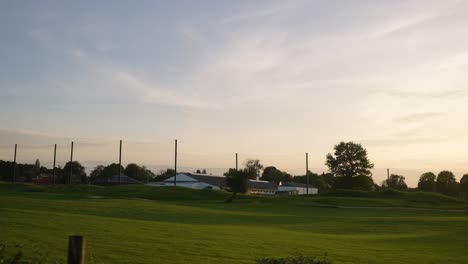 Ein-Weitläufiges-Golfplatzpanorama-Bei-Sonnenuntergang-–-Luftschwenk