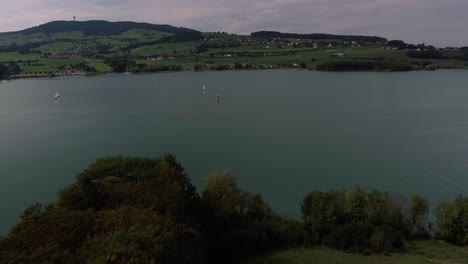 Vuelo-Aéreo-Sobre-La-Naturaleza-Mostrando-Veleros,-Lago-Gruyère