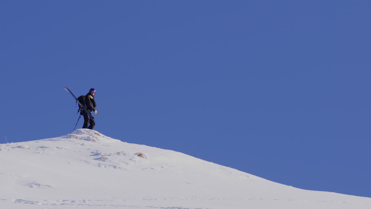 Freeride skier skinning up with Dents du Midi backdrop, then charging steep powder on a bluebird day near Champéry and Avoriaz.