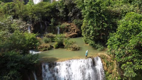 Un-Hombre-Camina-Al-Borde-De-La-Cascada-Thi-Lo-Su,-Ubicada-En-Lo-Profundo-De-La-Jungla,-Fuera-De-Los-Caminos-Trillados-Del-Norte-De-Tailandia-En-El-área-De-Umphang-En-El-Sudeste-Asiático