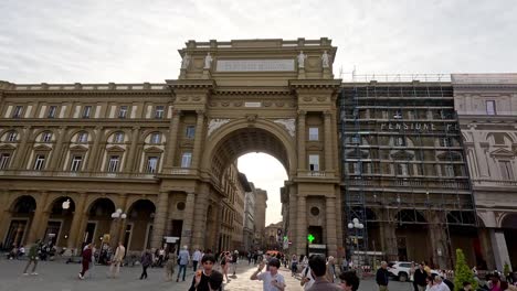 las multitudes se reúnen y se mueven a través de un arco icónico