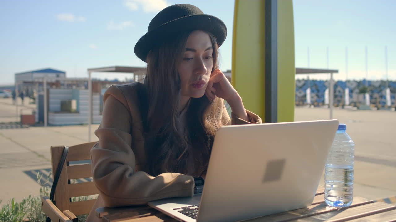 야외 카페에서 노트북으로 일하는 여자