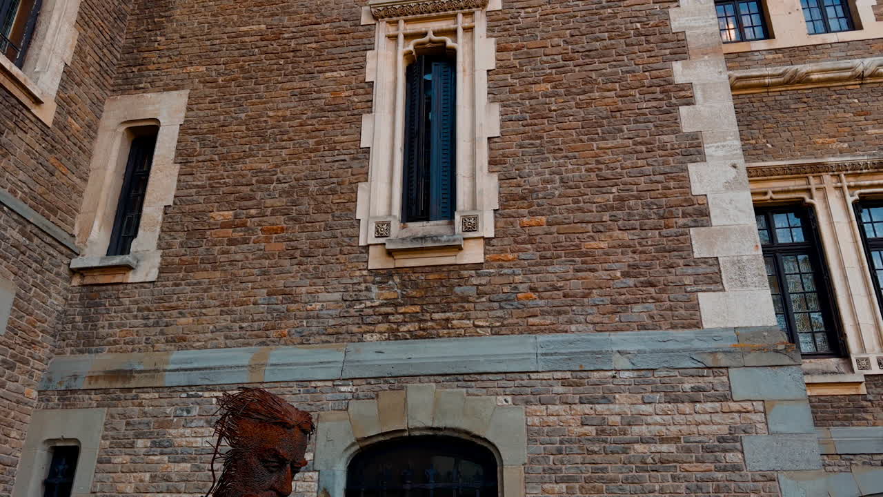 Old brick castle with thin windows. Low angle view on the beautiful old-fashioned building.