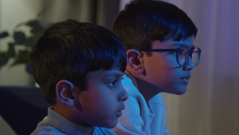 Close-Up-On-Hands-Of-Two-Young-Boys-At-Home-Playing-With-Computer-Games-Console-On-TV-Holding-Controllers-Late-At-Night-3