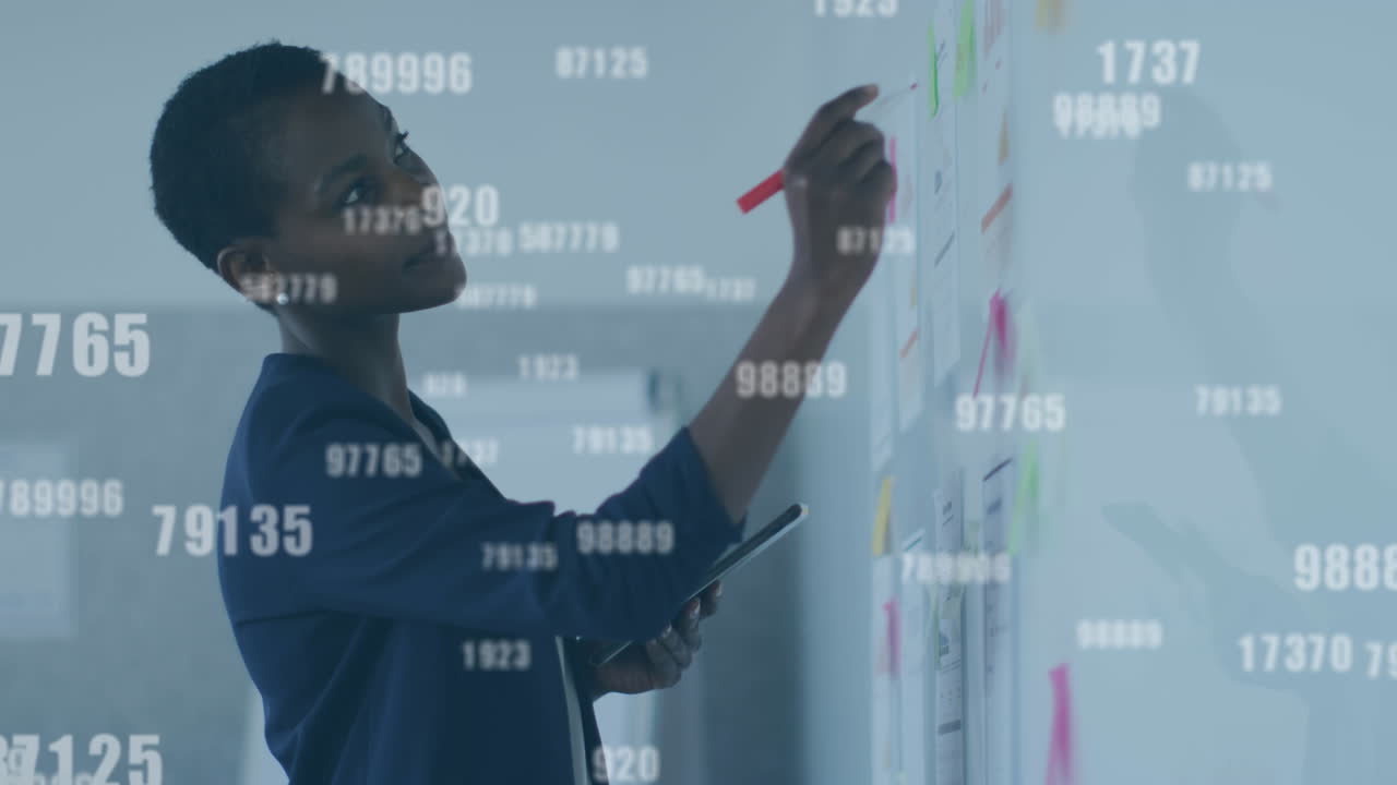 Animation of numbers processing over businesswoman writing on whiteboard in office