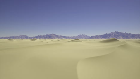 vast sandy landscape under clear blue sky with mountains in the distance