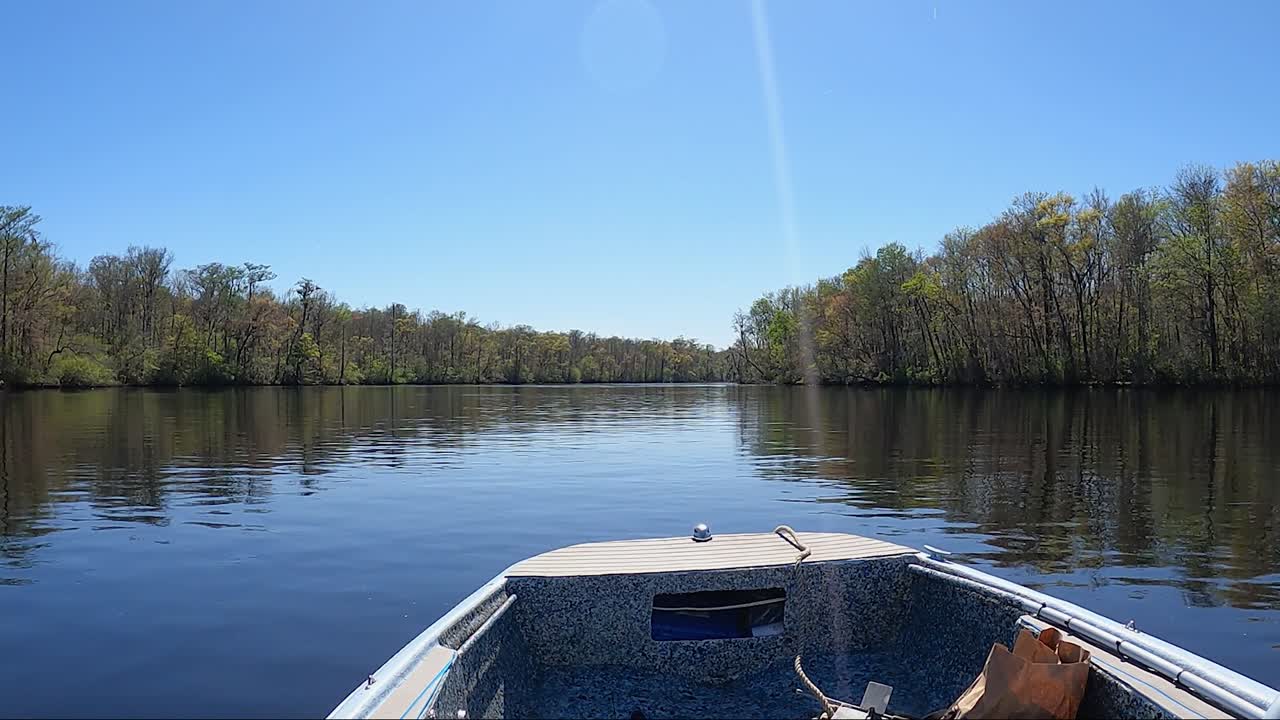 Prospettiva di navigazione su un fiume calmo in una barca a motore in una giornata autunnale di sole sul fiume Edisto, Carolina del Sud