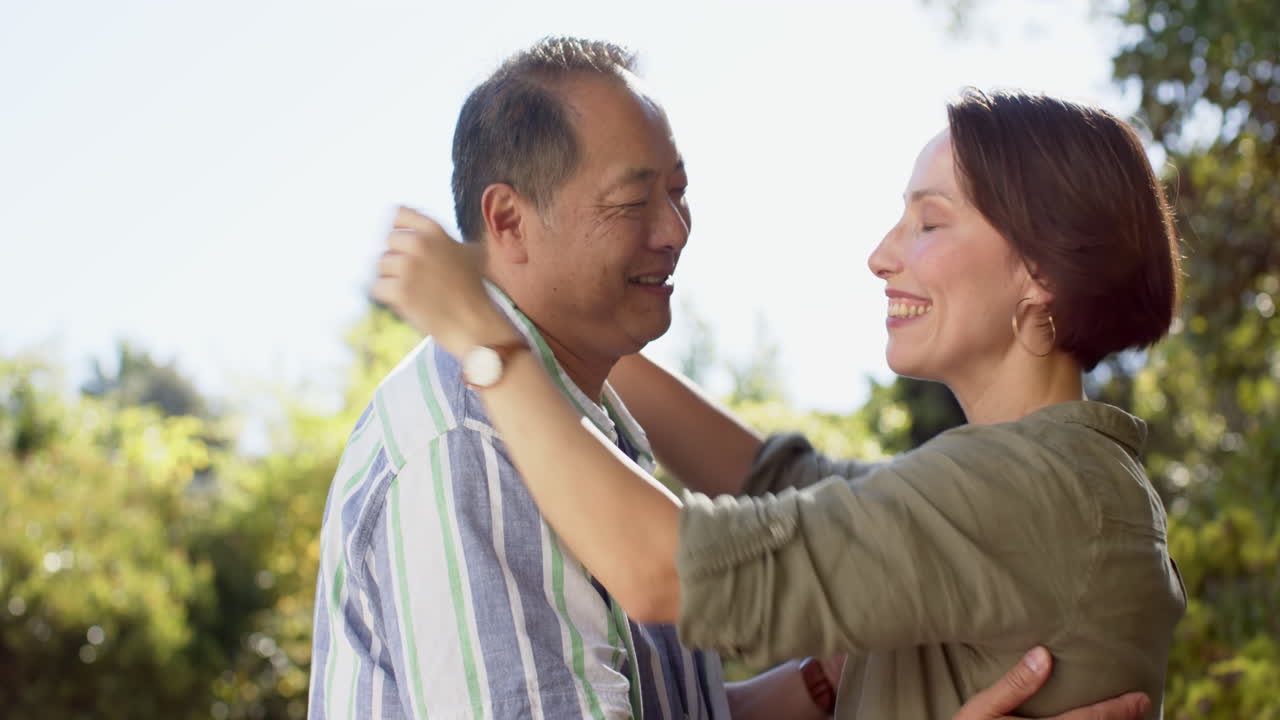 Embracing outdoors, smiling couple enjoying tender moment together