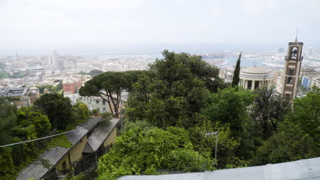 green vibrant trees and majestic cityscape of genoa in background, pan left view