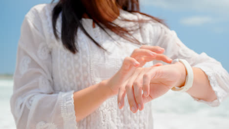 mid section of woman using smartwatch at beach 4k