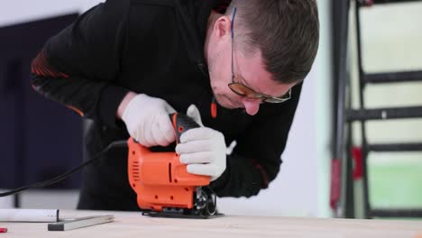 man cutting wood with a jigsaw