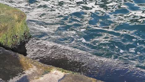 water crashing against rocks at the edge of a dock