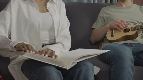 close up view of unrecognizable friends sitting on a sofa in a flat