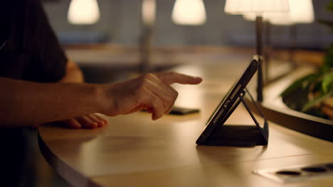 hombre agitando la pantalla de la tableta en el interior. hombre haciendo una videollamada en la oficina.
