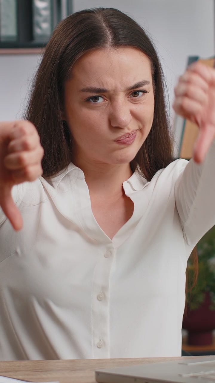 Upset businesswoman showing thumbs down dislike bad work disapproval dissatisfied feedback at office