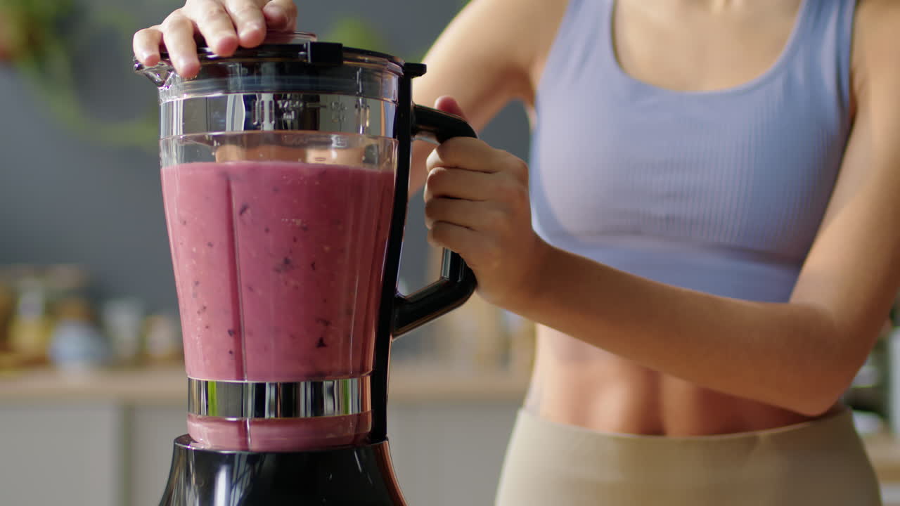 Slim Woman Preparing Smoothie in Kitchen Blender
