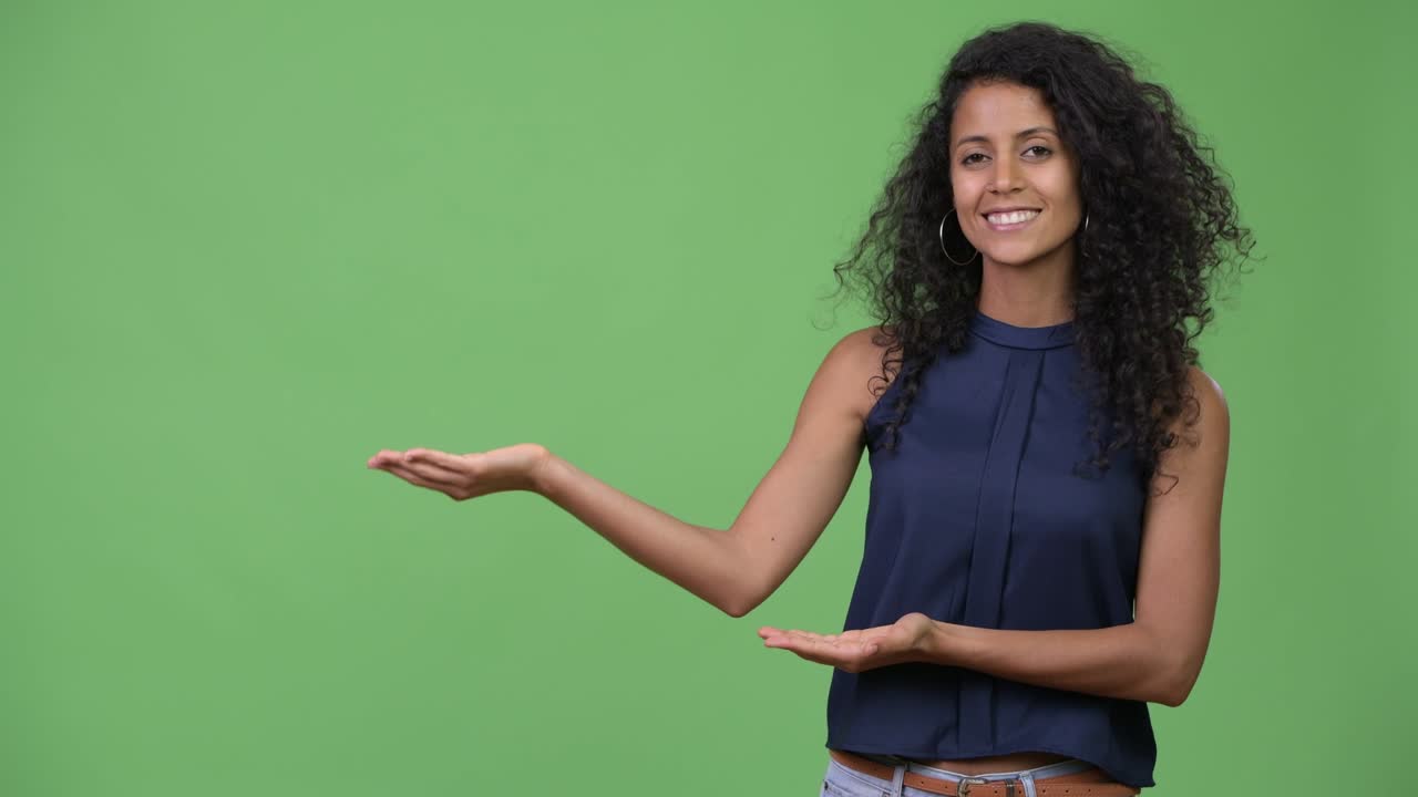 Young beautiful Hispanic businesswoman showing something