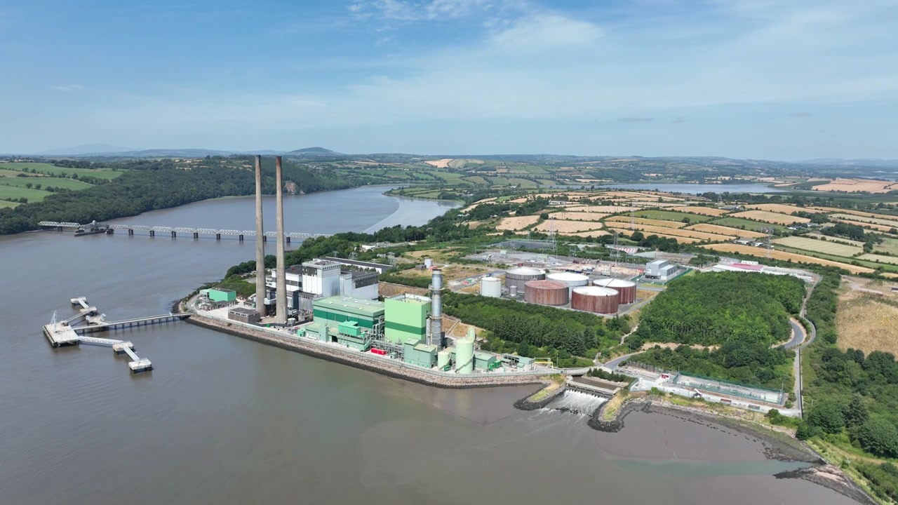 Vista aerea elevata di una centrale elettrica sul fiume Suir con l'estuario circostante, la costa e le strutture industriali