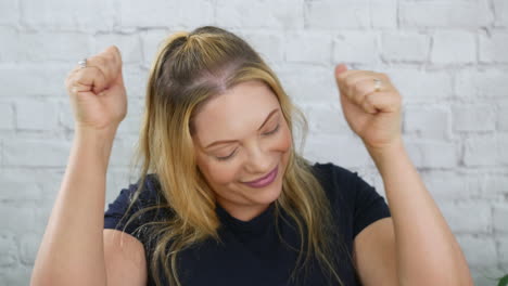 a happy blonde woman celebrating happy smiling and winning