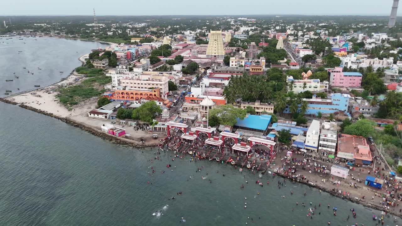 Aerial video of devotees offering prayers and performing rituals sacred Agni Theertham, a holy dip in the sea, where pilgrims take a dip to absolve their sins. Ramanathaswamy Temple in Rameshwaram