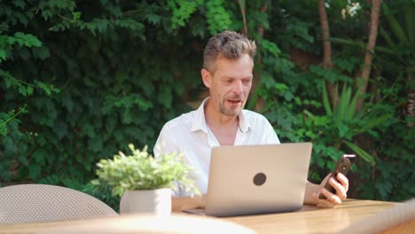 male entrepreneur making video call in street restaurant