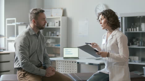 patient discussing symptoms with female doctor in medical office