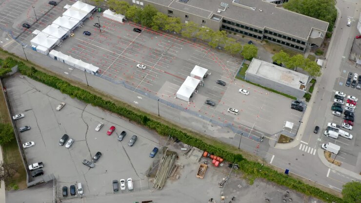 Cars Lined Up In Queue At Covid-19 Drive-Thru Testing And Vaccine Site At Daytime