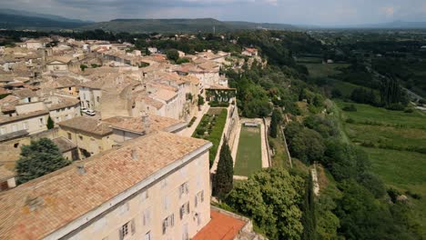 Drone-Desciende-A-Lo-Largo-De-Casas-De-Lauris-France-Con-Vistas-A-Campos-De-Viñedos-En-El-Campo