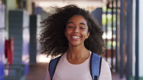 black teenage girl walks into focus in high school corridor