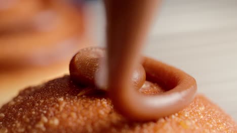 caramel donut being decorated cream filling