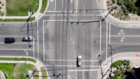 top down aerial view of intersection with cars passing through