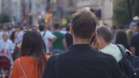 talking on the phone in the crowd.